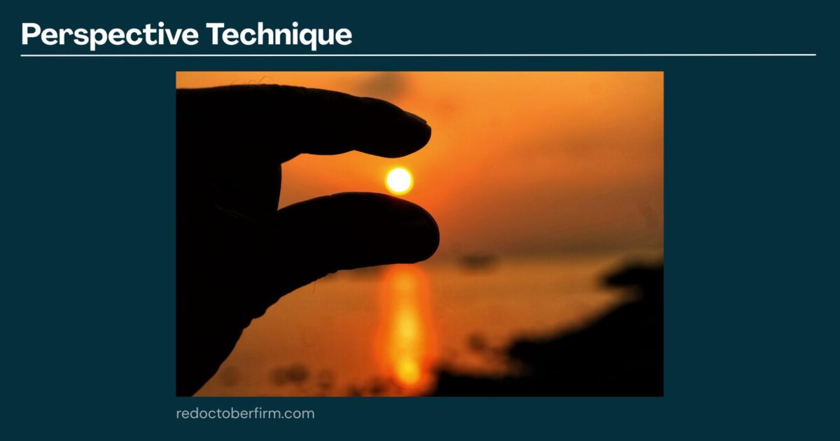 A Hand Positioned To Appear As If It Is Pinching The Setting Sun Over A Calm Body Of Water, Demonstrating A Perspective Photography Technique.