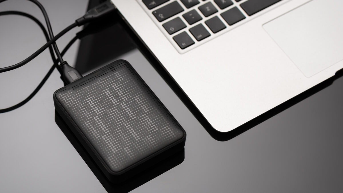 A Solar Charger Conveniently Placed Next To A Laptop On A Table.