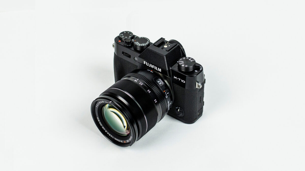 A Black Camera (Dslr) On A White Background.