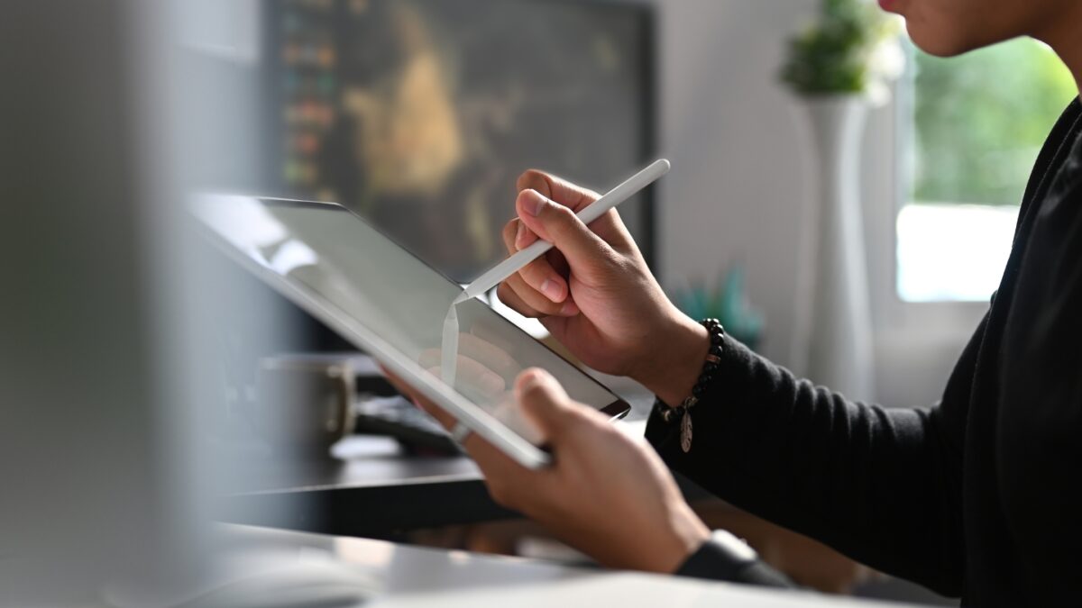 A Person Using A Tablet To Edit Photos With A Pen.