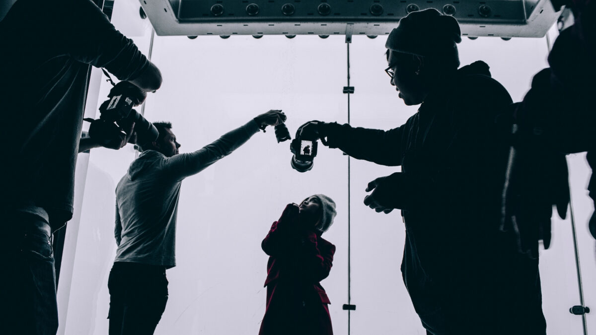 A Group Of People Join A Photography Group And Stand In Front Of A Camera.