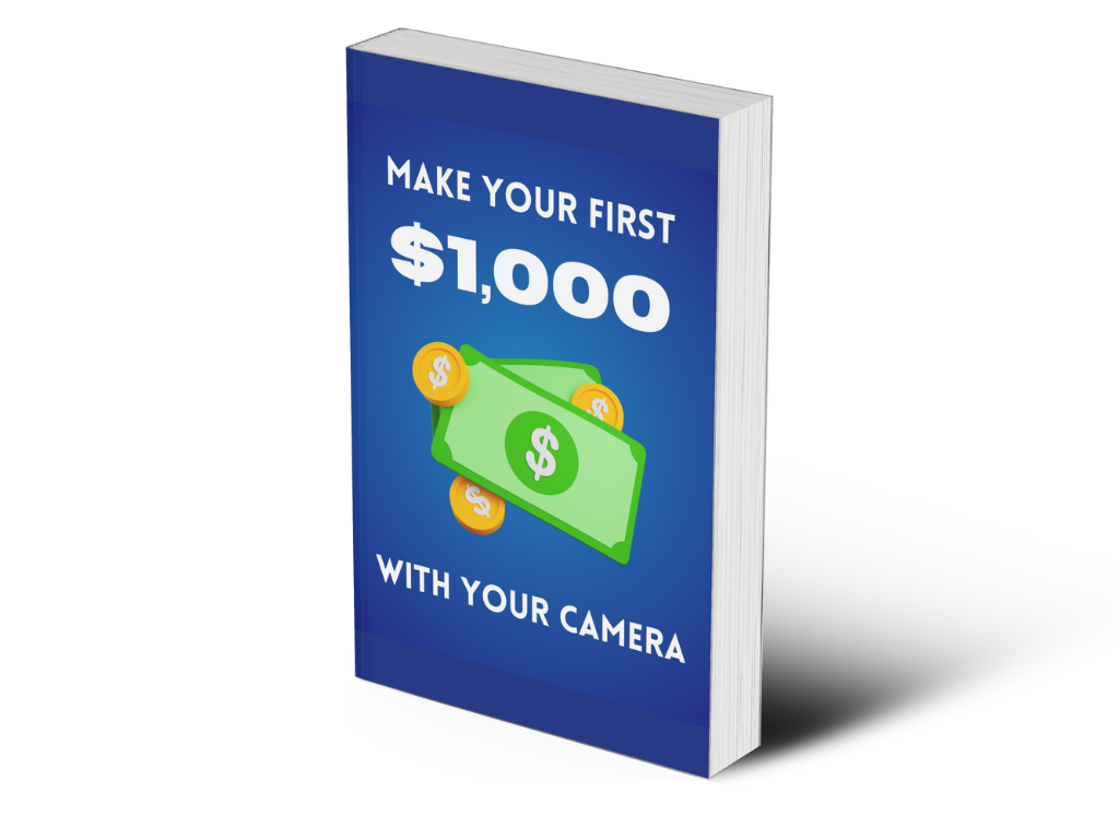 A Book With A Blue Cover Titled &Quot;Make Your First $1,000 With Your Camera&Quot; Featuring An Image Of Cash And Coins.