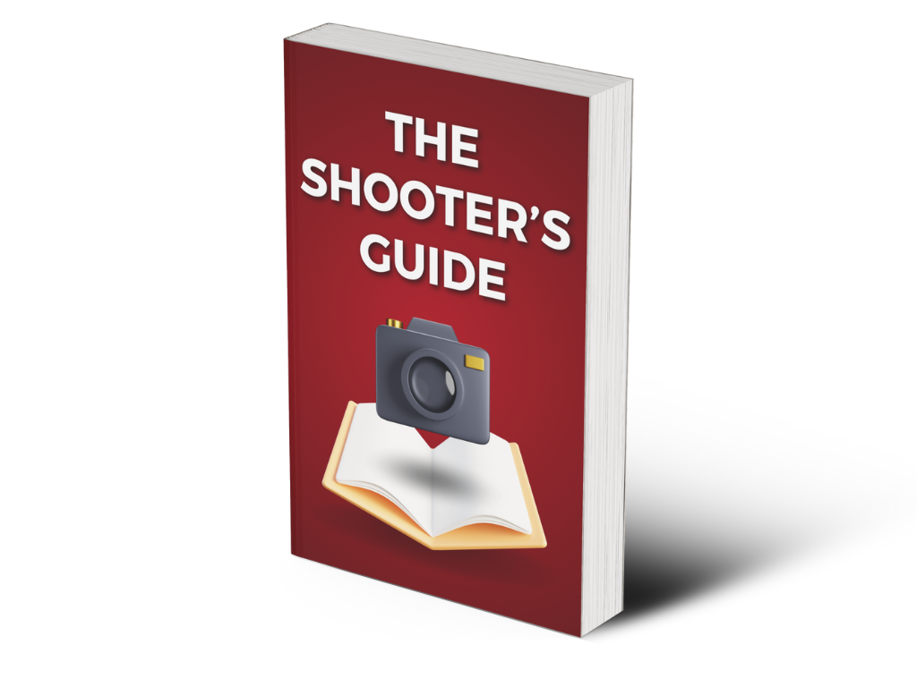 A Book Titled &Quot;The Shooter'S Guide&Quot; With An Icon Of A Camera And An Open Book On A Red Cover.