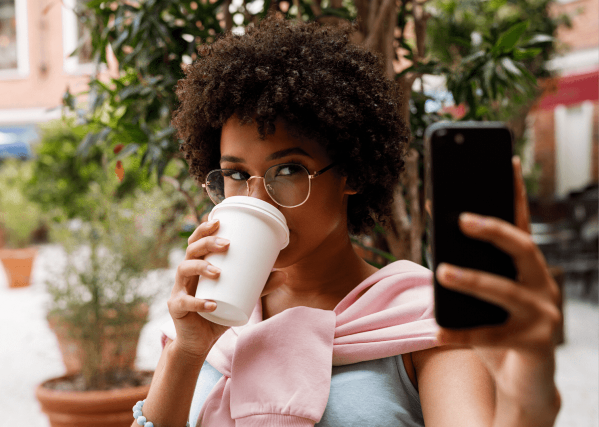 Young Woman Capturing A Coffee-Focused Selfie As Part Of Her Content Marketing Strategy.